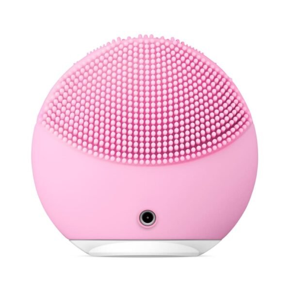 Pink silicone facial cleansing brush with densely packed soft bristles and a small front port for charging or 연결.