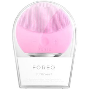 Foreo Luna mini 2 facial cleansing device in pink with silicone bristles and control buttons on the front side, displayed in its clear case. Brand: Foreo. Model: Luna mini 2.