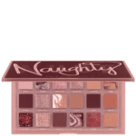 Huda Beauty Naughty eyeshadow palette open, showing 18 pink-toned shades in square pans with a pink lid logo area