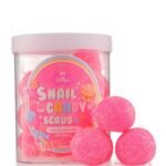 Pink candy-scented sugar scrub in a clear jar with a candy-themed label, accompanied by pink bath bombs beside it.